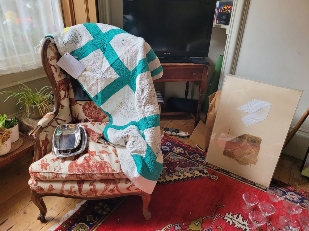 Image of a chair, a quilt and a painting